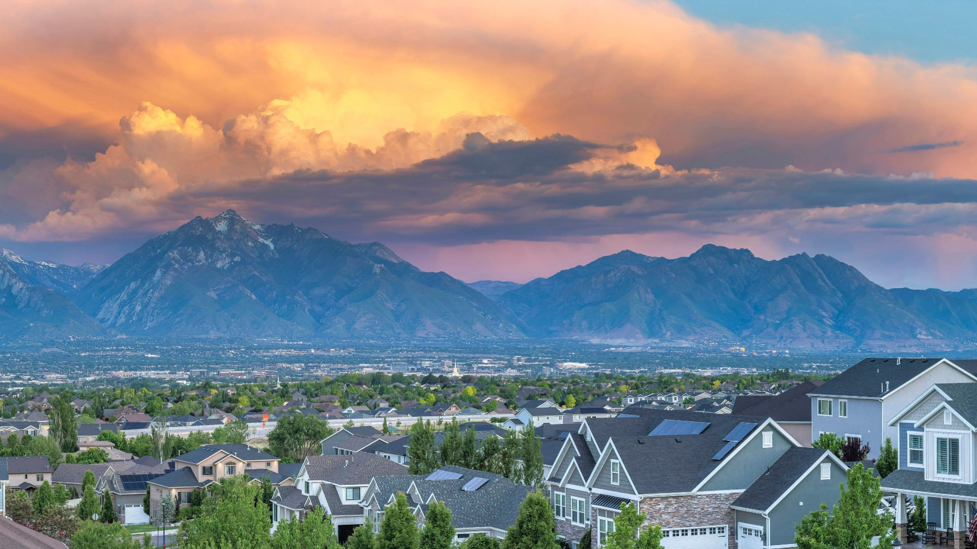 Utah neighborhood street with homes and the Wasatch mountains at sunset